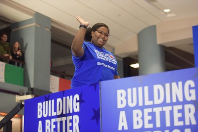 NEA Aspiring Educator Dajsha Williams waves as she walks onto the stage to introduce President Biden.