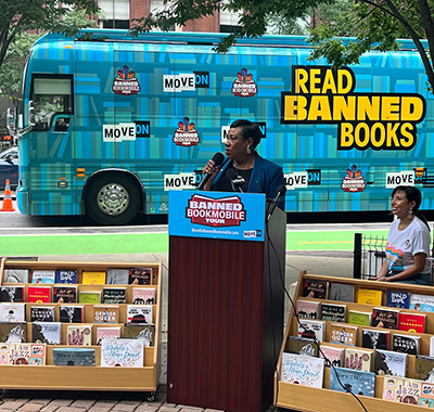 NEA President Becky Pringle behind a podium during banned bookmobile tour.