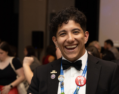 A man smiling dressed in a tuxedo. 