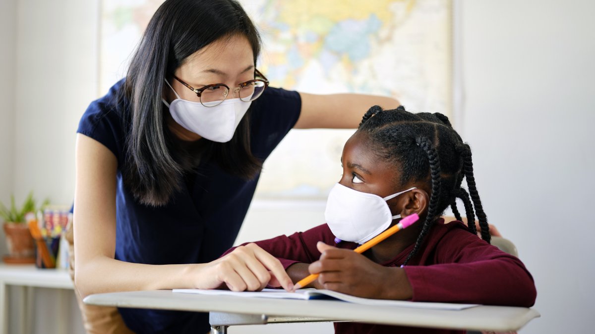 elementary aged teacher in classroom with student