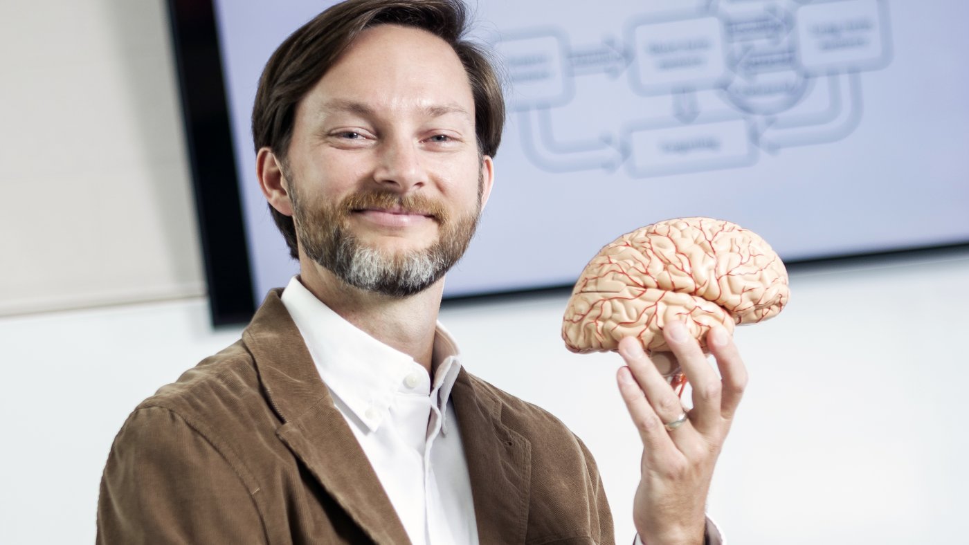 Alabama teacher Blake Harvard holds up a model of a human brain