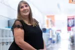 Laura Warren stands in her school's hallway looking over her right shoulder