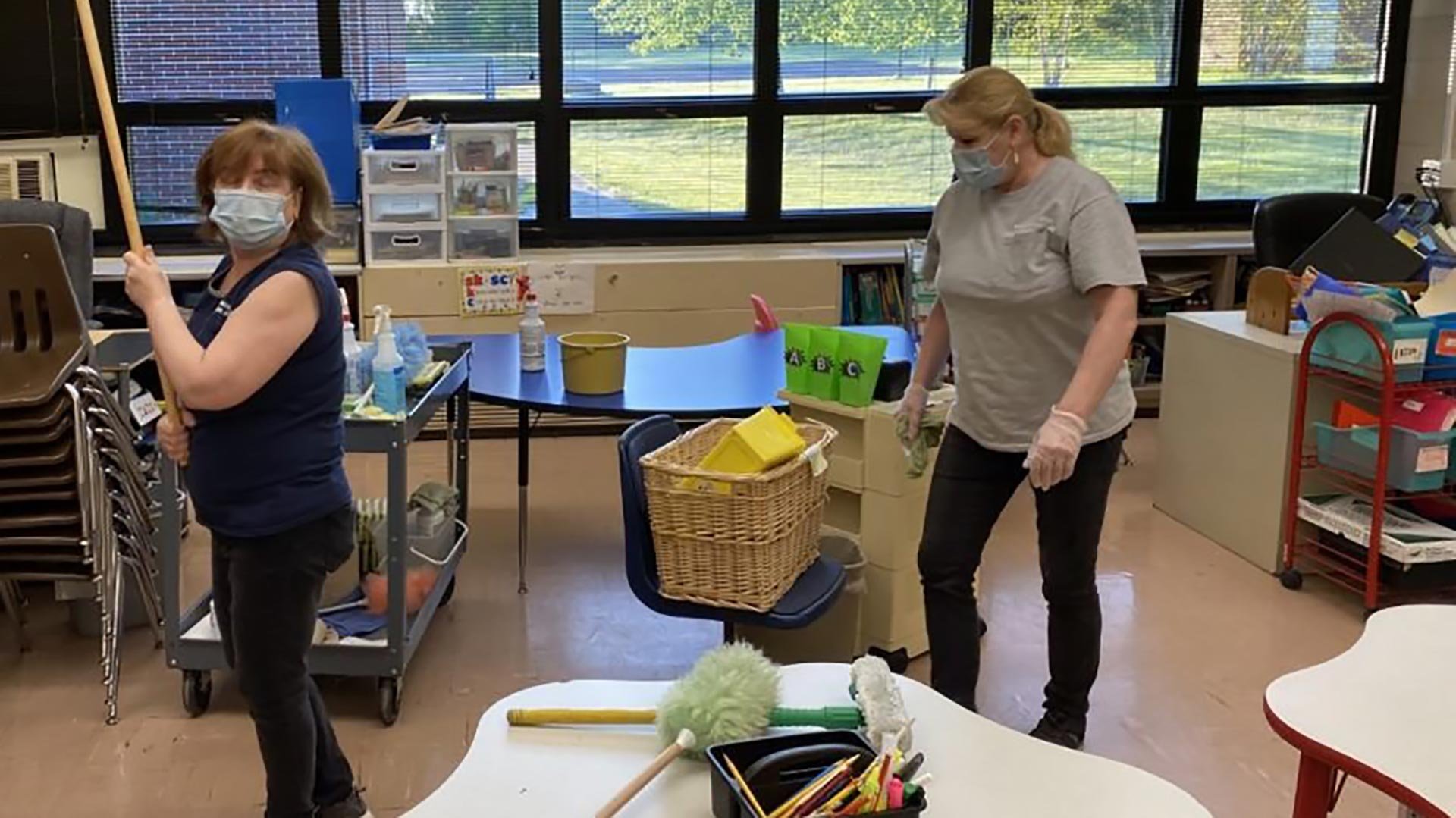 Two female teachers sterilize a classroom