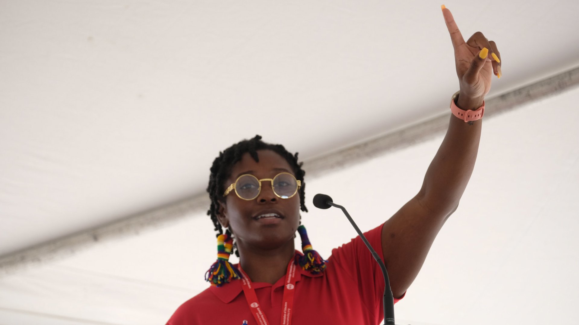 A Black woman holds her hand in the air