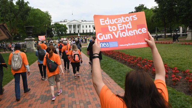 Educators in front of the White House with a sign that says 