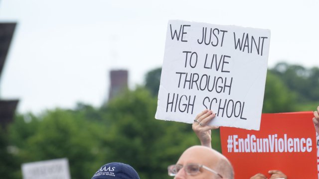 person at a rally holding a sign at a rally that reads 