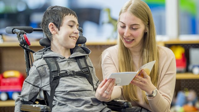 teacher reading to student in wheelchair