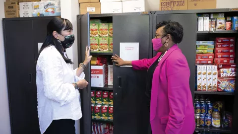 NEA President Becky Pringle greets social worker Gloria Ho at her school's food pantry