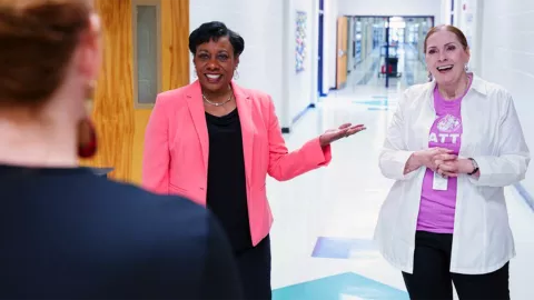 NEA President Becky Pringle stands next to educator Dorothy Welch in a school hallway.