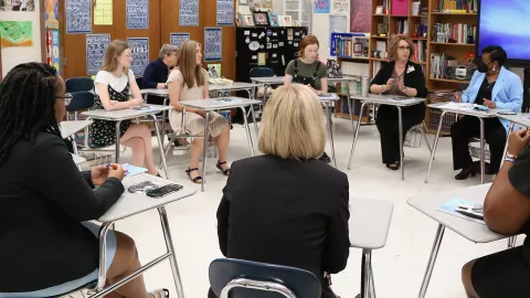 NEA President speaks with North Carolina educators sitting in a circle.