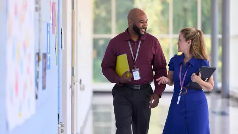 Two teachers walking down hallway