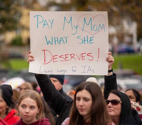 Photo of sign: Pay My Mom What She Deserves