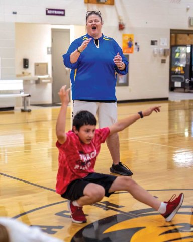 Sheila Peterson working with students in a gymnasium.