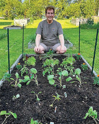 Wisconsin’s Tom Zigan sitting by his vegetable garden.