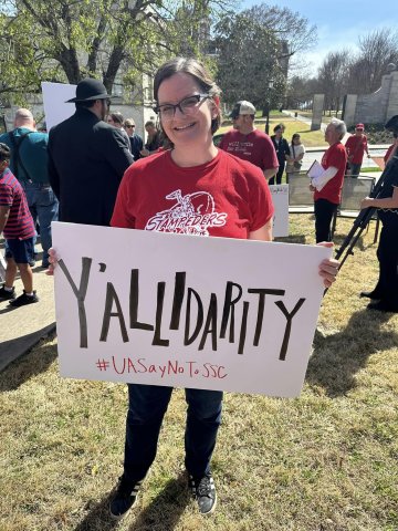 Arkansas member holding sign